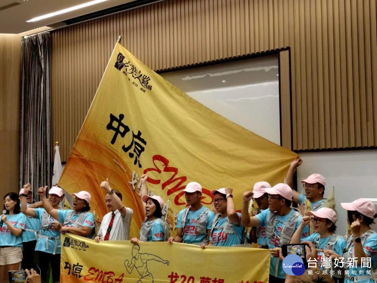  中原EMBA成員高舉隊旗，象徵群體合作與生命連結的教育實踐。