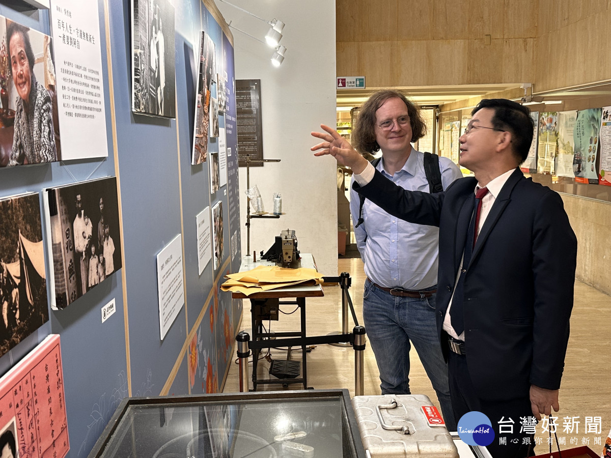 台中市政府客家事務委員會主任委員江俊龍向蘇費翔主任導覽老照片展。