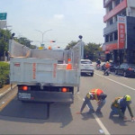 清潔隊員在車陣中撿拾民眾掉落之千元大鈔