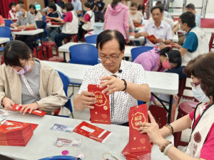 林世賢市長協助工作人員將禮金裝袋。圖／記者鄧富珍翻攝