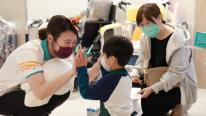 孩子在杏一門市人員的引導下進行購物任務，家長與治療師在旁鼓勵陪伴。