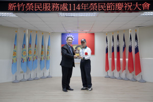 鞠宗顯處長頒贈八二三抗戰英雄呂木廷榮民楷模獎牌，表揚榮民犧牲奉獻精神。