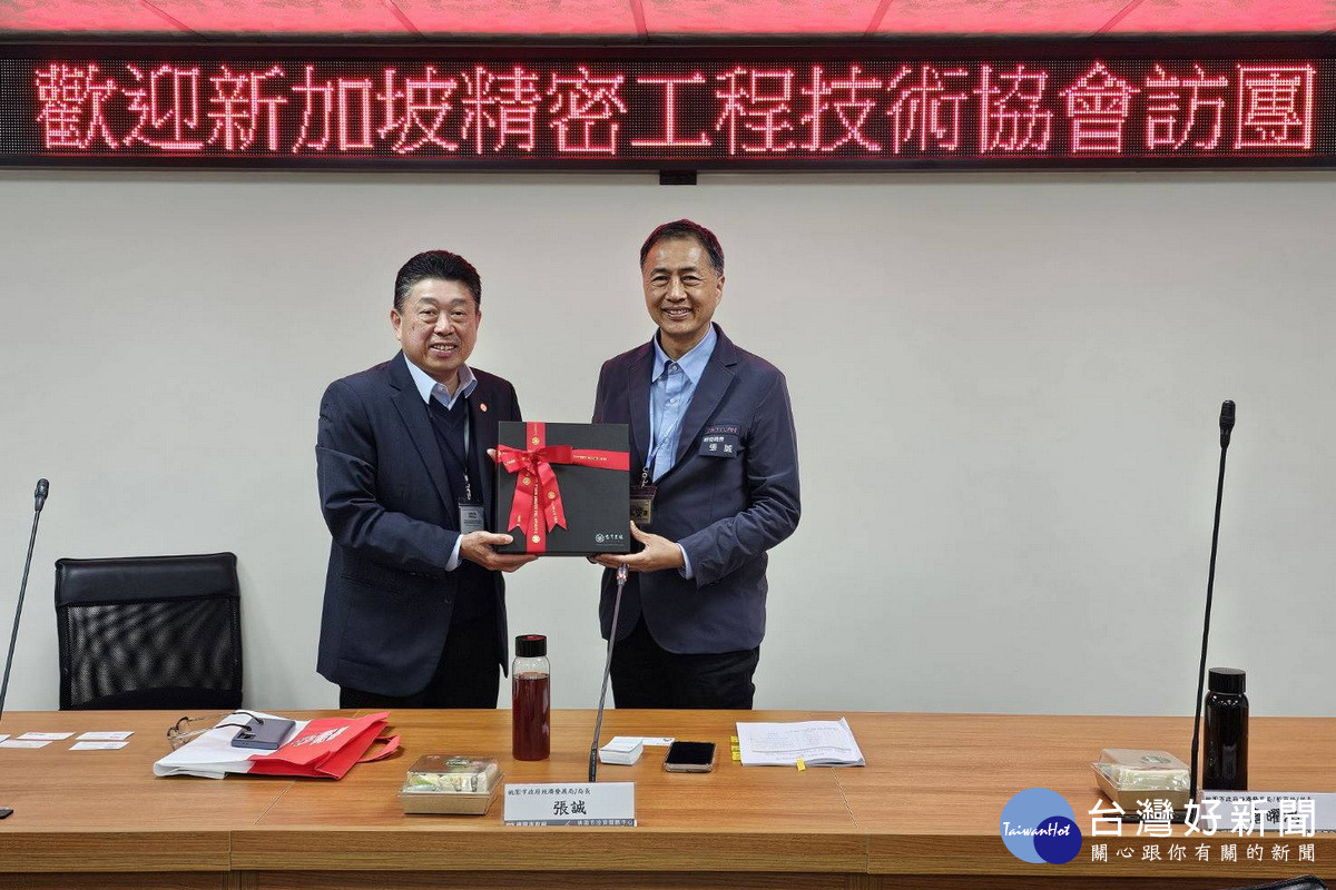 桃市府經發局長張誠致贈禮物予新加坡精密工程技術協會代表。