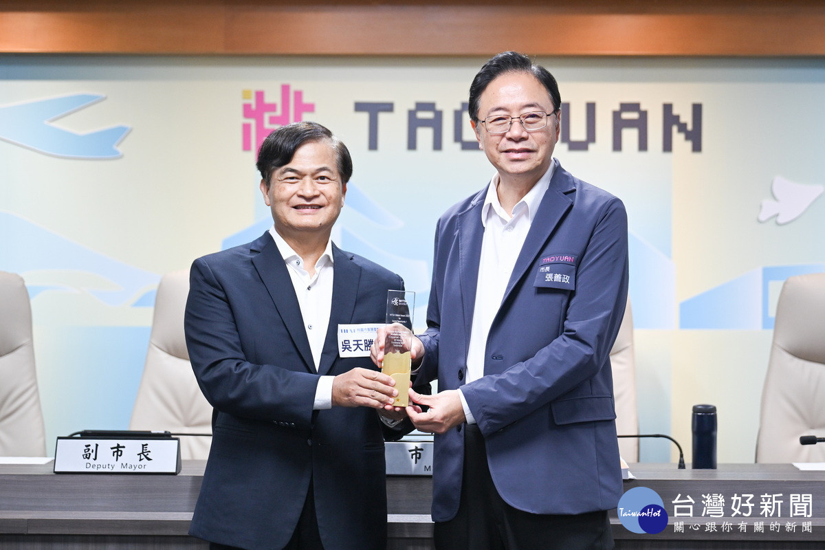 桃園市長張善政接受智慧產業學院院長吳天勝獻獎。