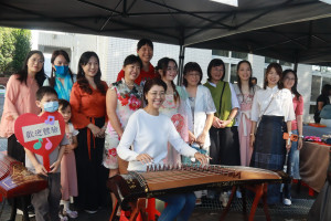 許淑華到各攤位體驗，彈起古箏甚覺有趣。（記者扶小萍攝）