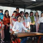 許淑華到各攤位體驗，彈起古箏甚覺有趣。（記者扶小萍攝）