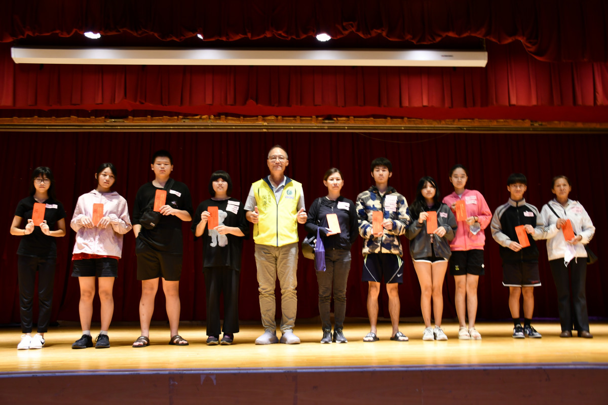 市公所社會課長吳澤生代表林世賢市長發放教育補助費後逐批和受領者合影留念。圖/彰化市公所提供