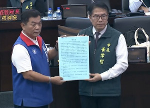 台南市議員盧崑福（左）趁總質詢時遞交民眾檢舉函給台南市長黃偉哲（右），要求政風、法制等單位嚴懲不法。