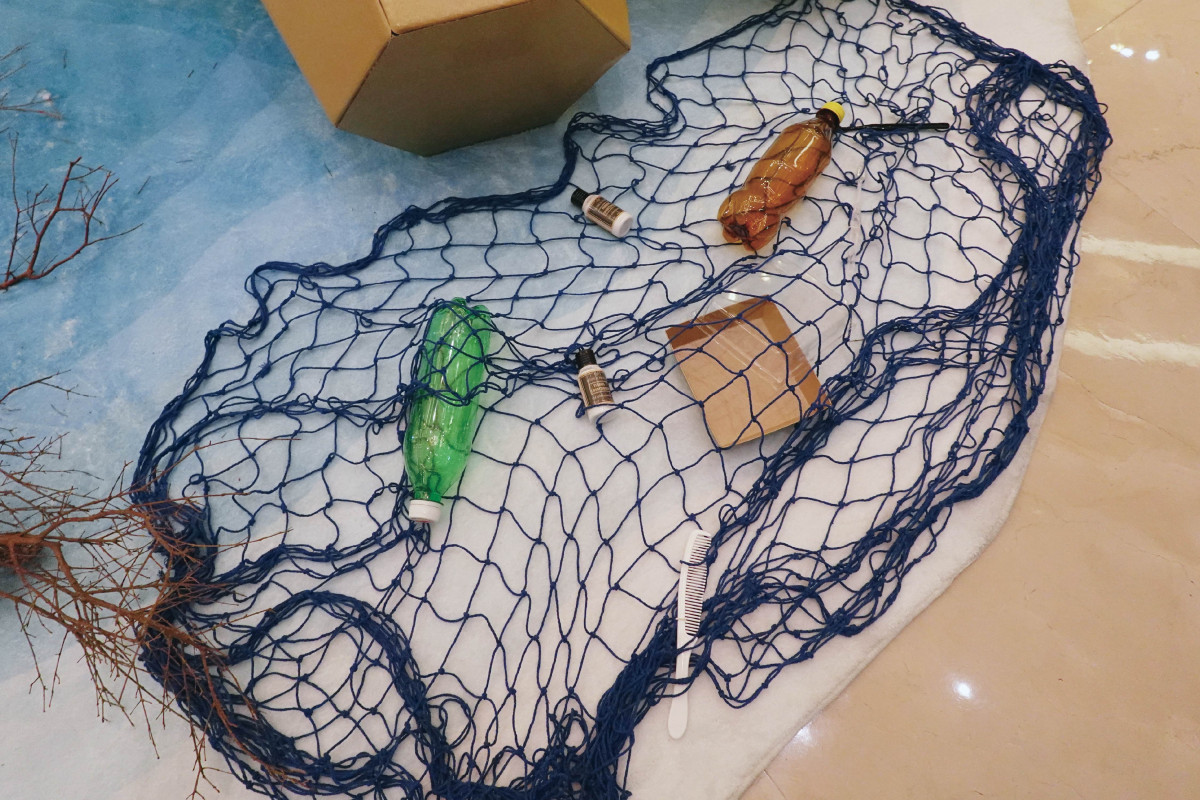 耶誕裝置以可再生紙材、漁網線條與海廢議題視覺呈現,呼應飯店長期推動的永續行動。