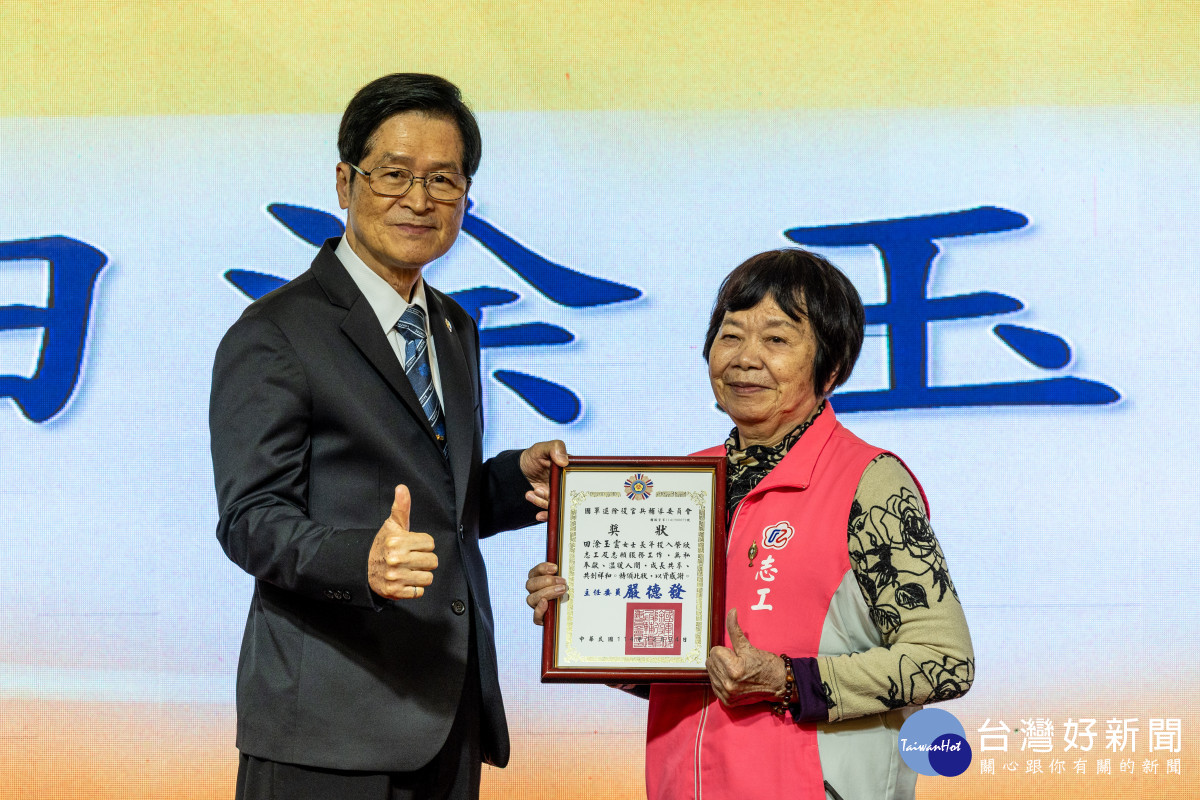 輔導會嚴德發主委(左)頒發資深志工獎予田涂玉雲女士(右)。