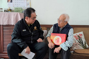 關懷榮民杜爺爺(右)鞠宗顯處長(左)，與伯伯話家常，並致贈雞精禮盒。