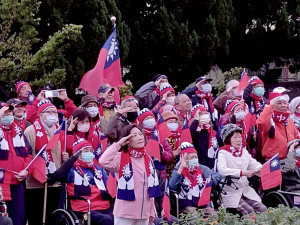 榮家主任白恩惠(前中)帶領住民長輩向冉冉上升的國旗致敬。