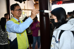 開化寺管理人林世賢市長持文昌帝君的智慧筆逐一為考生「點」頭象徵開智慧。圖／彰化市公所提供