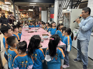 碗粿霞黃姓負責人向幼童說明手作紅龜粿。（記者扶小萍攝）