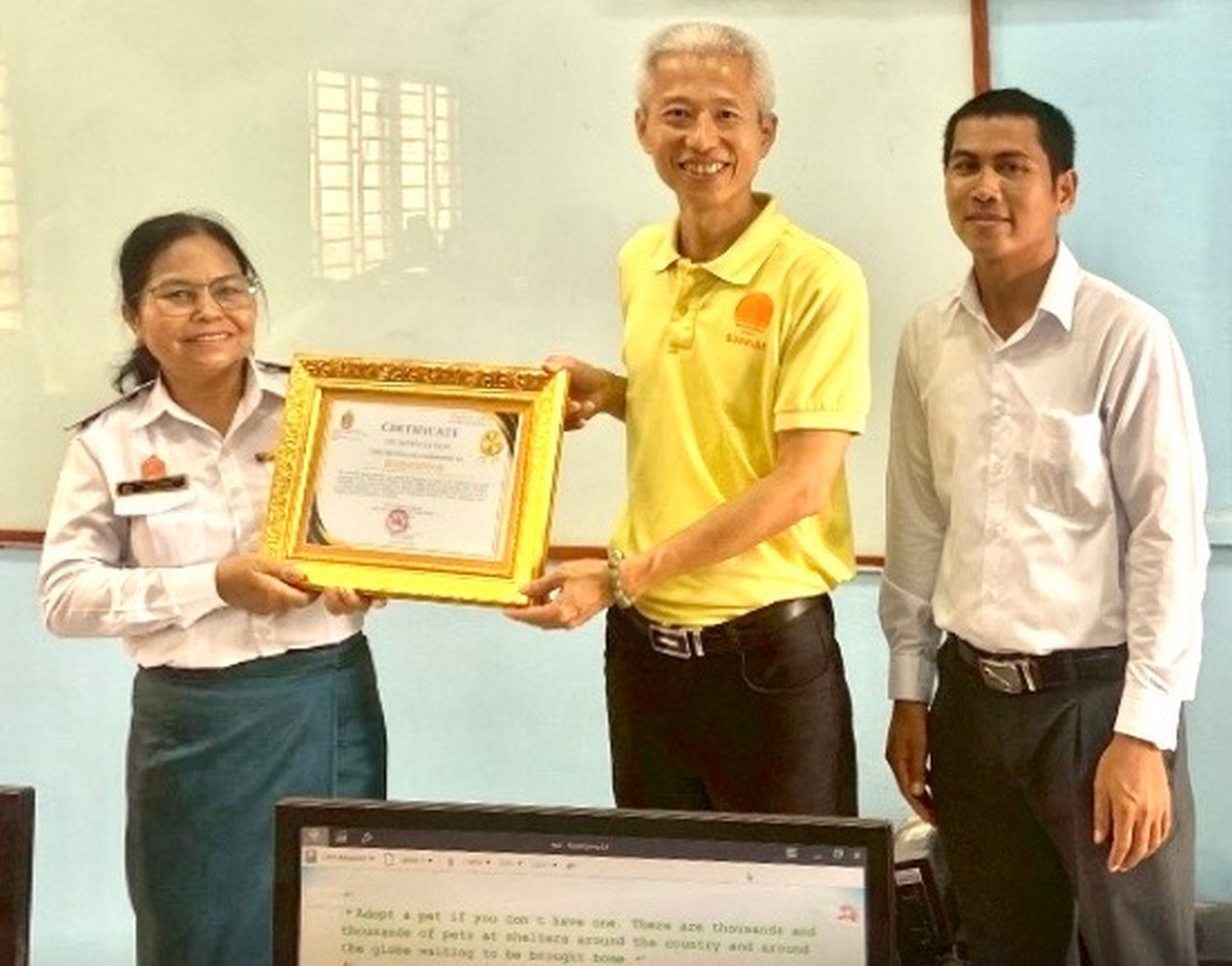 受助學校Hun Sen Phnom Sruoch High School校長(左),傑出校友李政鍠博士(中)代表暨大,於該校致贈感謝狀儀式中合影。(暨大提供)