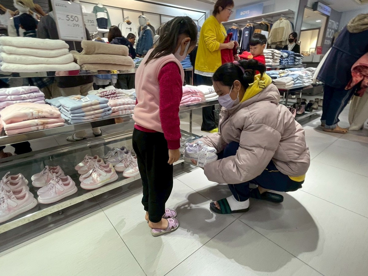 家庭幫孩子試穿鞋子。(南投家扶中心提供)