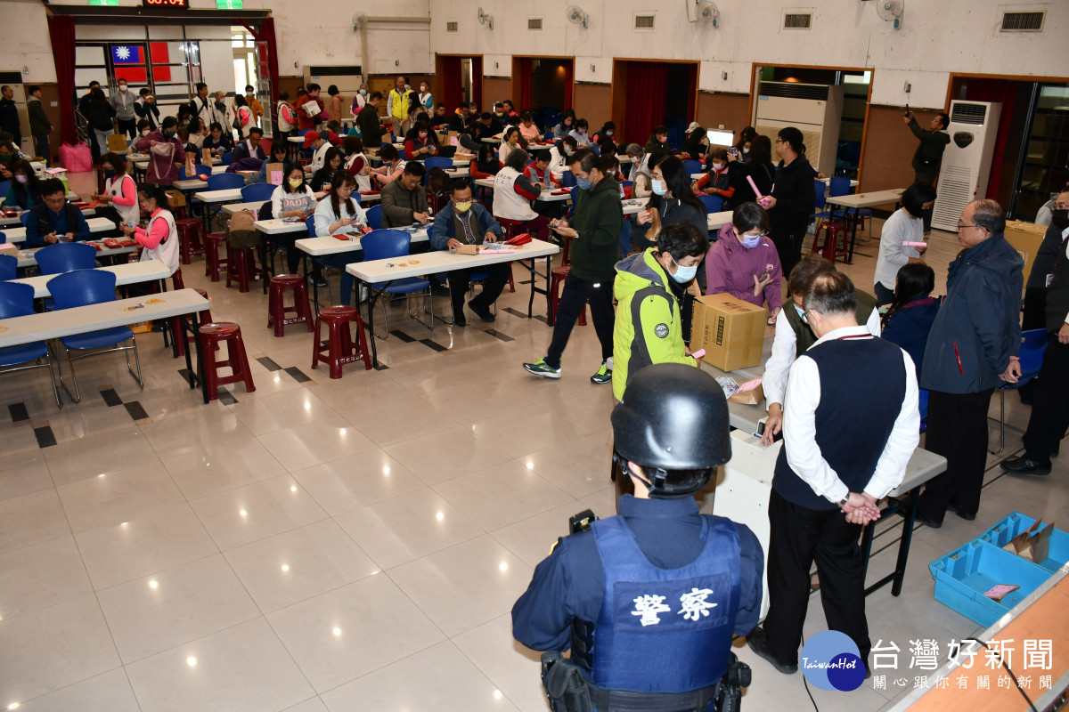 1百多名人員在彰化生活藝文館點鈔與裝鈔配槍員警全程護衛。圖/彰化市公所提供