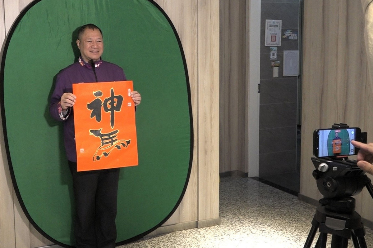 大園區長余誌松親自入鏡拍攝拜年短片，手持書「神馬」春聯向鄉親拜年。