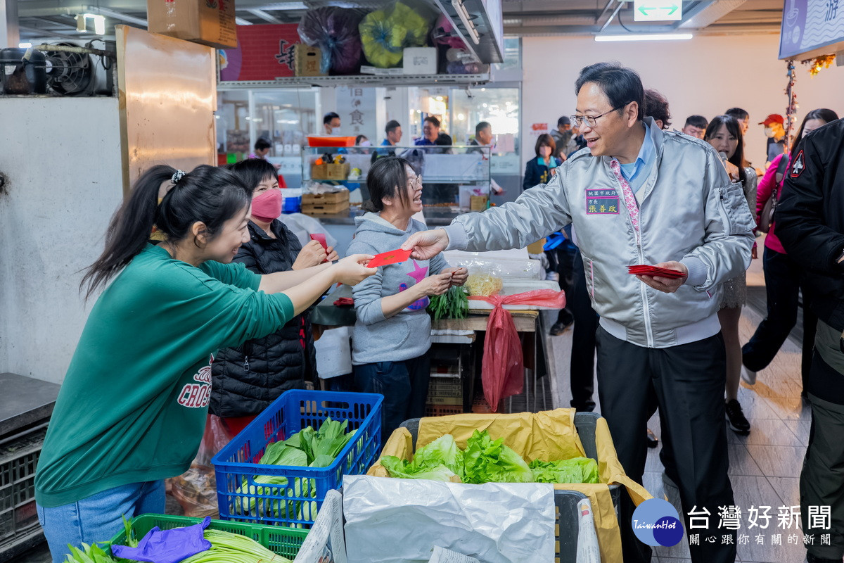 桃園市長張善政出席「2026桃園年貨大街」開幕記者會，於市場內發放馬年紅包袋。<br />

