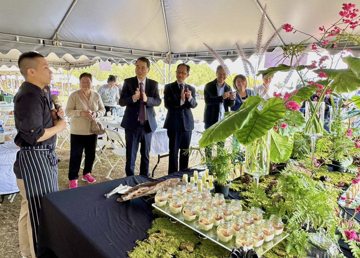 張文騰主廚(左一)現場說明生態保育意象融入餐飲設計的綠色餐桌，獲到場貴賓的讚賞。（暨大提供）