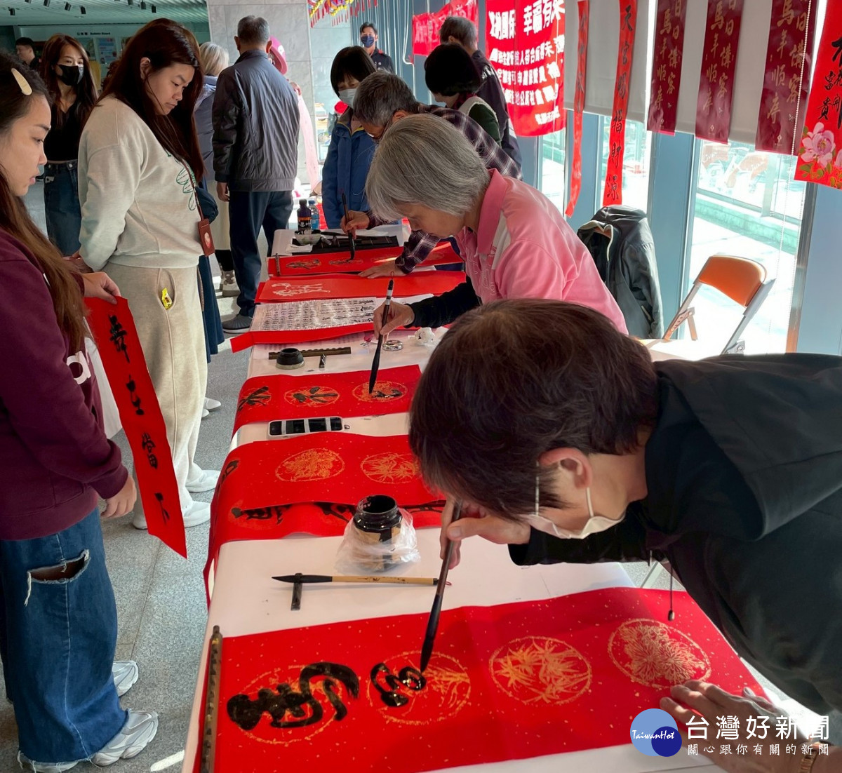 市民朋友井然有序地排隊挑選心儀墨寶，現場墨香四溢，洋溢著濃厚喜慶氛圍。