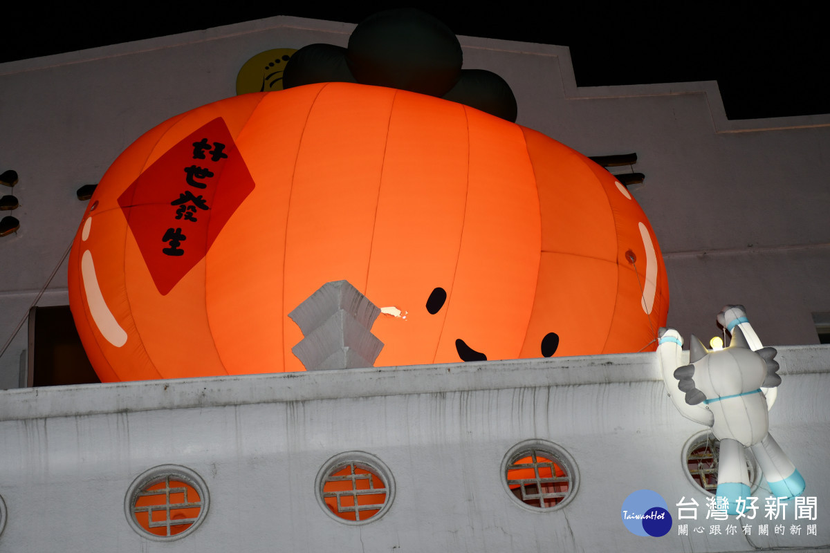 彰化市公所正門頂上柿子造型的「好世發生」花燈以及像在攀爬的半半人偶人夜相當吸睛。圖／彰化市公所提供