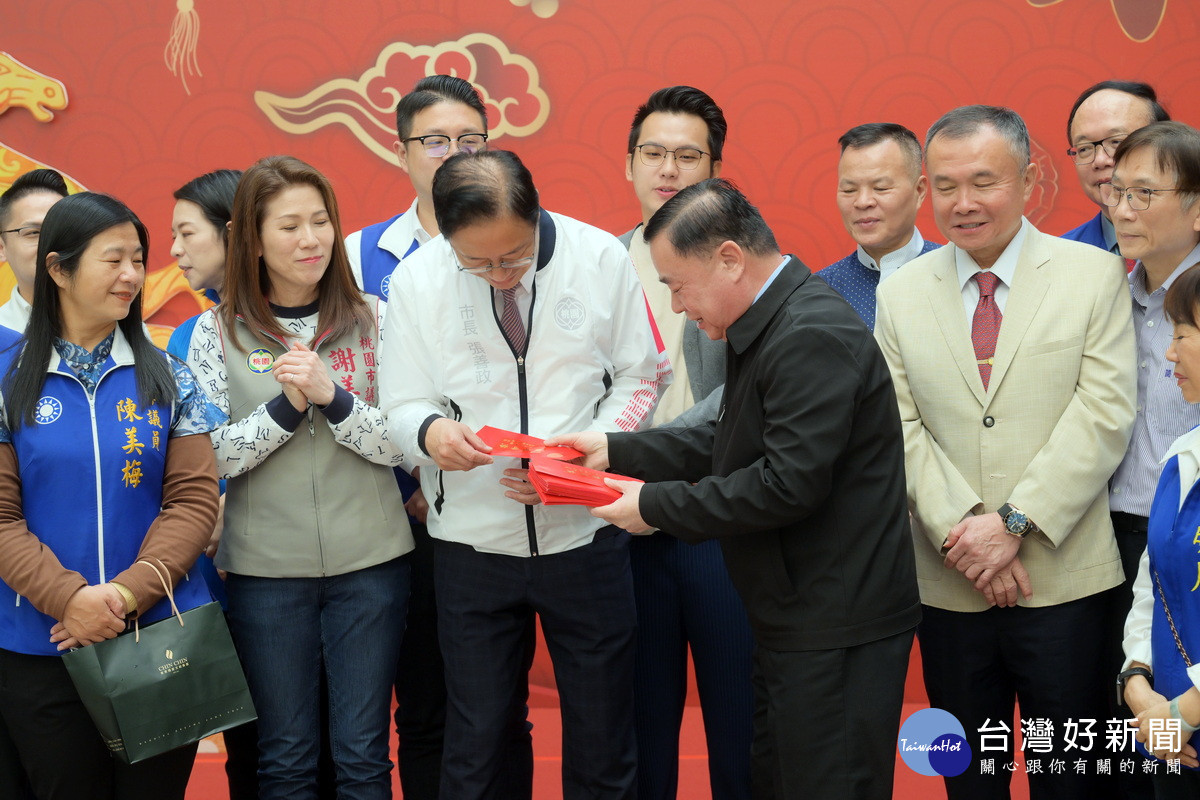 桃園市議會議長邱奕勝發放紅包給桃園市長張善政祝福新年快樂。<br />

