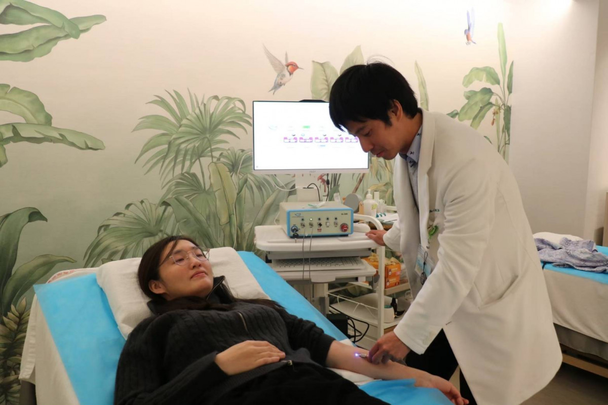 邱伯恩副主任幫陳小姐做血液雷射治療。圖／秀傳醫院提供