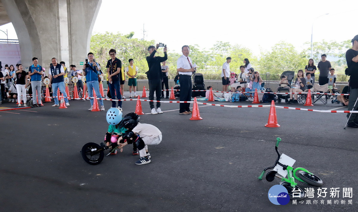 穿淺色衣服的小朋友扶起跌倒的小朋友再繼續比賽。(記者扶小萍攝)