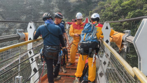 一名桃園籍邱姓民眾於信義鄉雙龍吊橋墜橋輕生，警義消暗夜馳援。（南投縣消防局提供）