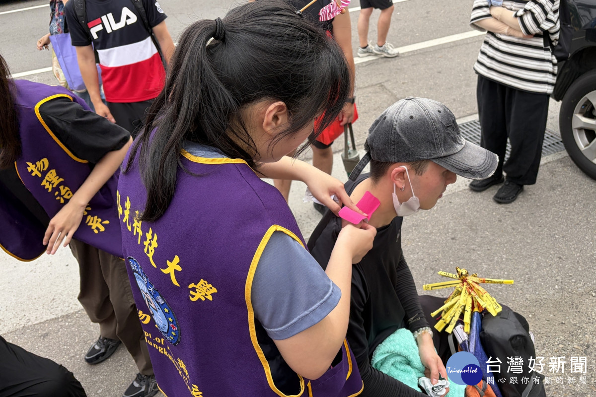 香客因背負許多隨身物品，導致上肢與頸部疲勞，前來接受弘光科大物治系學生貼紮服務。（弘光科大提供）