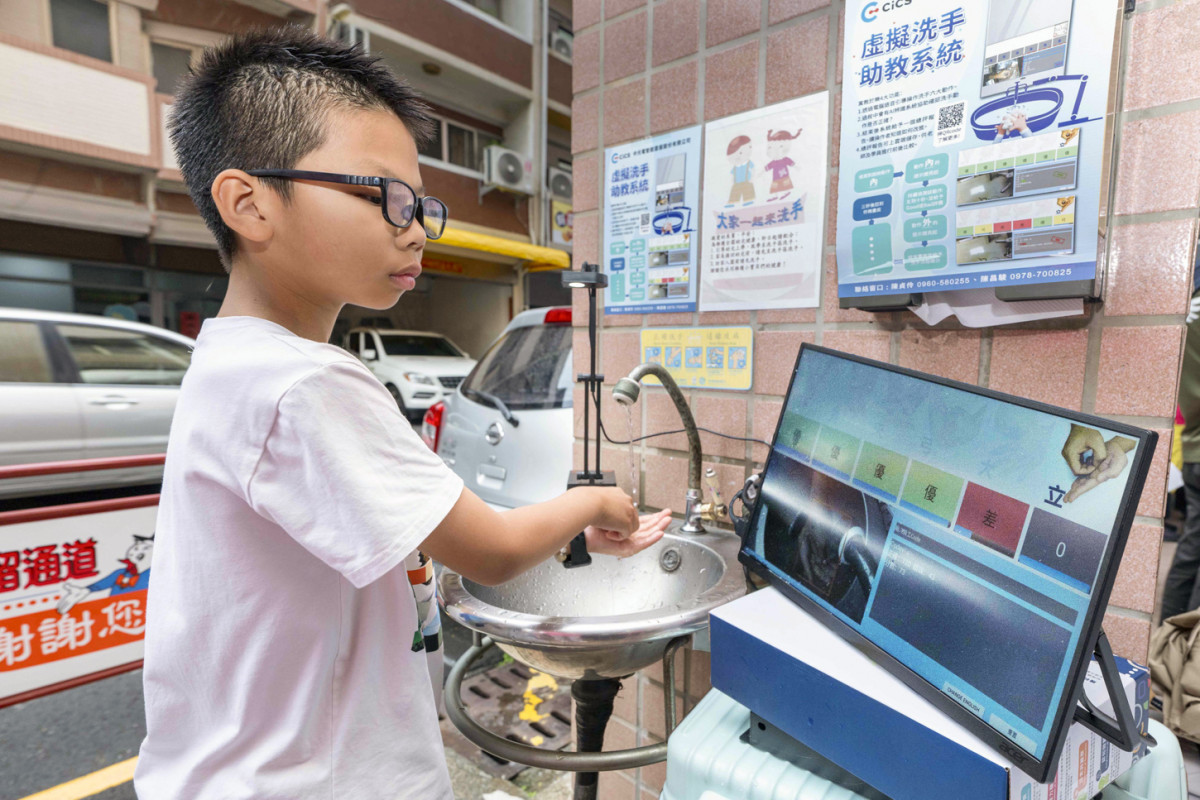 男童專注看著螢幕，畫面上呈現手部影像，這是AI正進行即時影像分析。圖／彰基提供