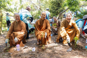 佛光山台北道場住持滿謙法師(左)、中區總住持覺居法師(中)與國際佛光會秘書長覺培法師(右)，為荒地種下台灣原生樹種。圖/佛光山提供