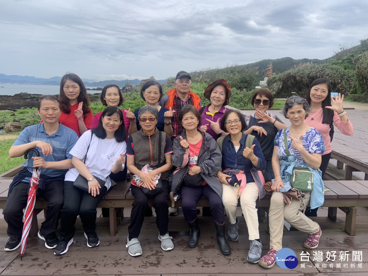 社工室林吉勝主任(前排左1)與志工夥伴於野柳海岸景觀前合影，留下珍貴同樂時光