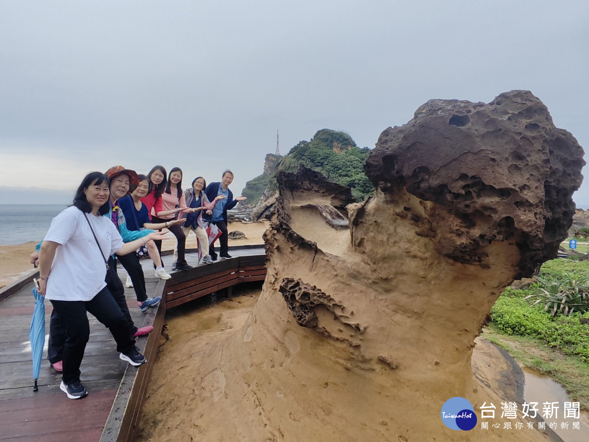 志工夥伴與造型奇岩合影，以生動活潑的手勢為旅程增添歡樂趣味