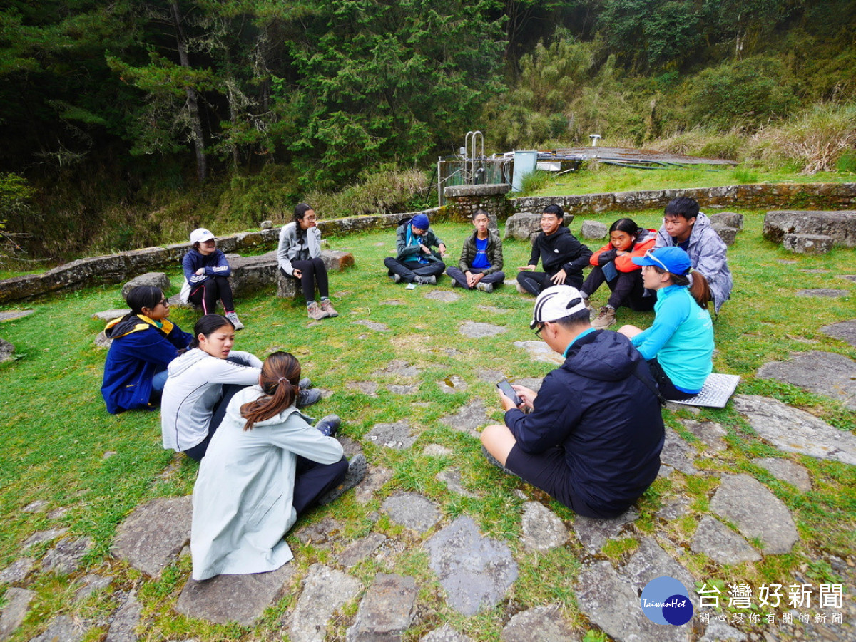 嚮導與學員在排雲登山服務中心前席地而坐進行營隊課程。（圖/玉管處提供）