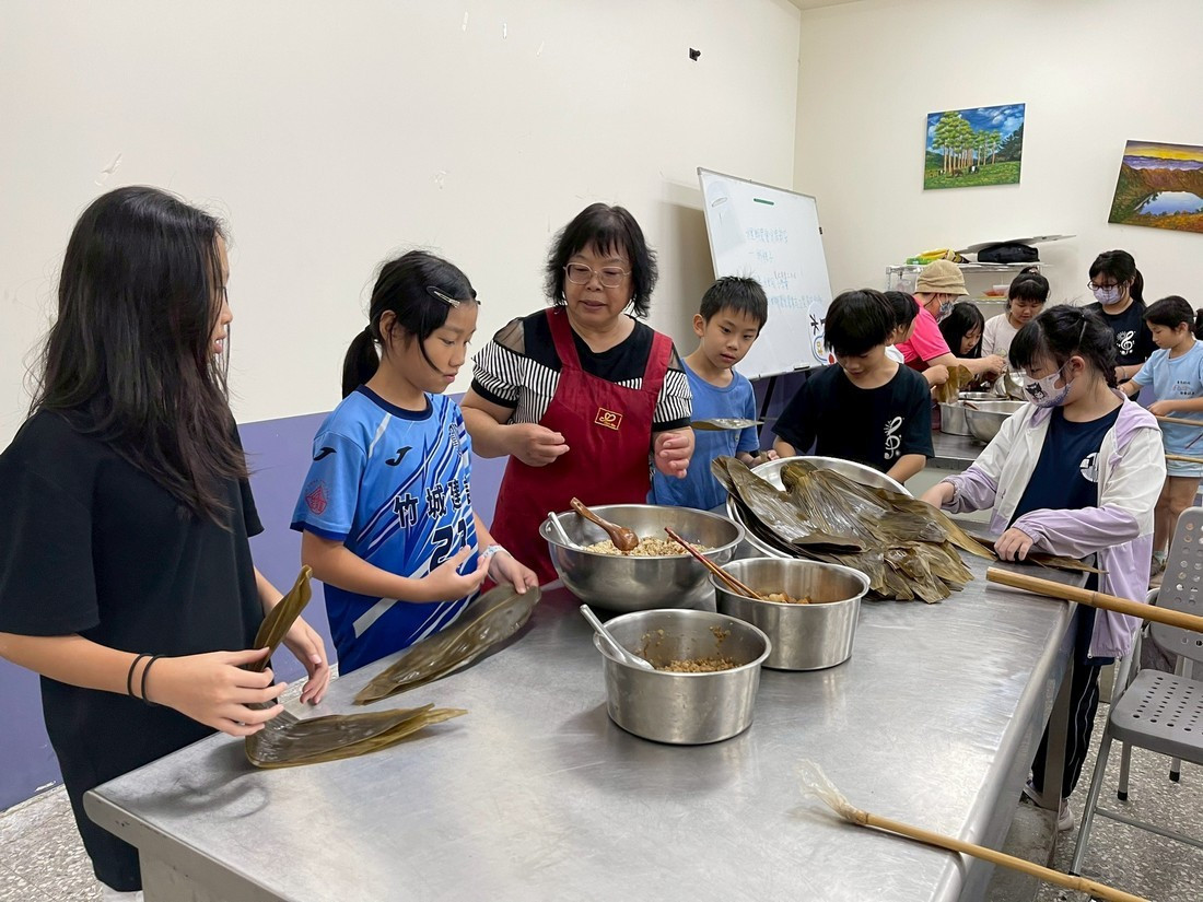 水里國小學生於與家政志工媽媽們一同體驗包粽子,感受傳統節日的溫馨與意義。