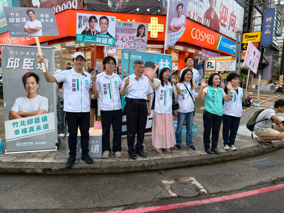柯文哲與竹北市長候選人邱臣遠一行現身路口，吸引市民與過往車輛的目光。
