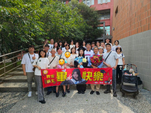 暨大114年度畢業典禮國企系畢業生張彧萌(著學士服)，與25位家族成員和一隻寵物毛孩組成的「超重量級應援團」合影。（暨大提供）