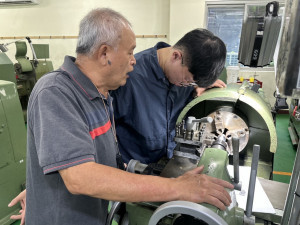 CNC數控工具機實務技能班，老師指導訓練學員操作機台。