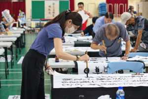 社會組第一名胡禕倩揮毫。（上緯諒茶獎提供）