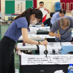 社會組第一名胡禕倩揮毫。（上緯諒茶獎提供）