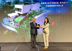 和倫開發總經理翁毓羚自高齡93歲曾任營建署署長的黃南淵榮譽理事長手中接過獎座。圖/業者提供