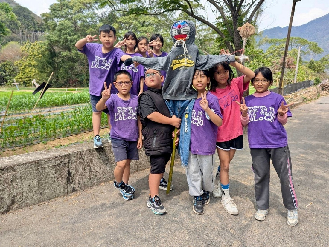圖說:人和國小學生思考如何趕鳥,於小米田間假設自己做的稻草人。