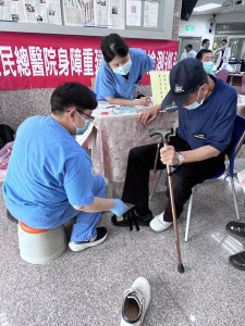 臺北榮民總醫院身障重建中心陳衍如物理治療師(左1)、劉姿辰職能治療師(左2)為行動不便榮民進行輔具適配服務。