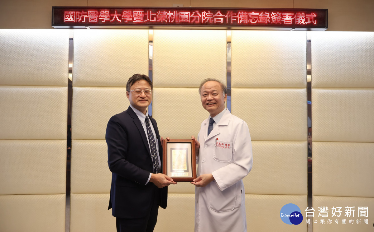 北榮桃園分院彭家勛院長(右)致贈「軍榮情誼 永誌紀念」紀念琉璃獎座予國防醫學大學林致源校長(左),象徵雙方珍視彼此情誼及攜手合作的共同願景