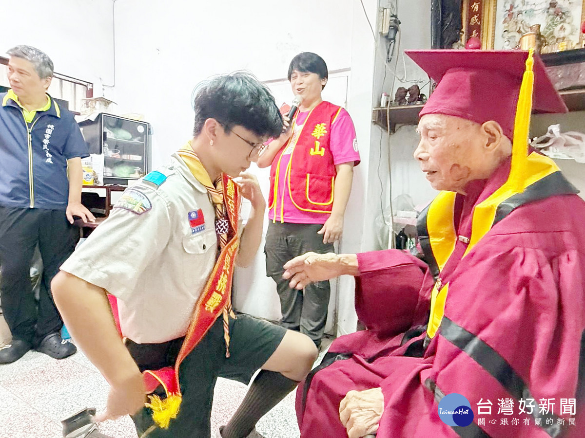 王爺爺將代表榮譽的值星帶,配戴在童軍肩上並給予祝福,象徵世代傳承
