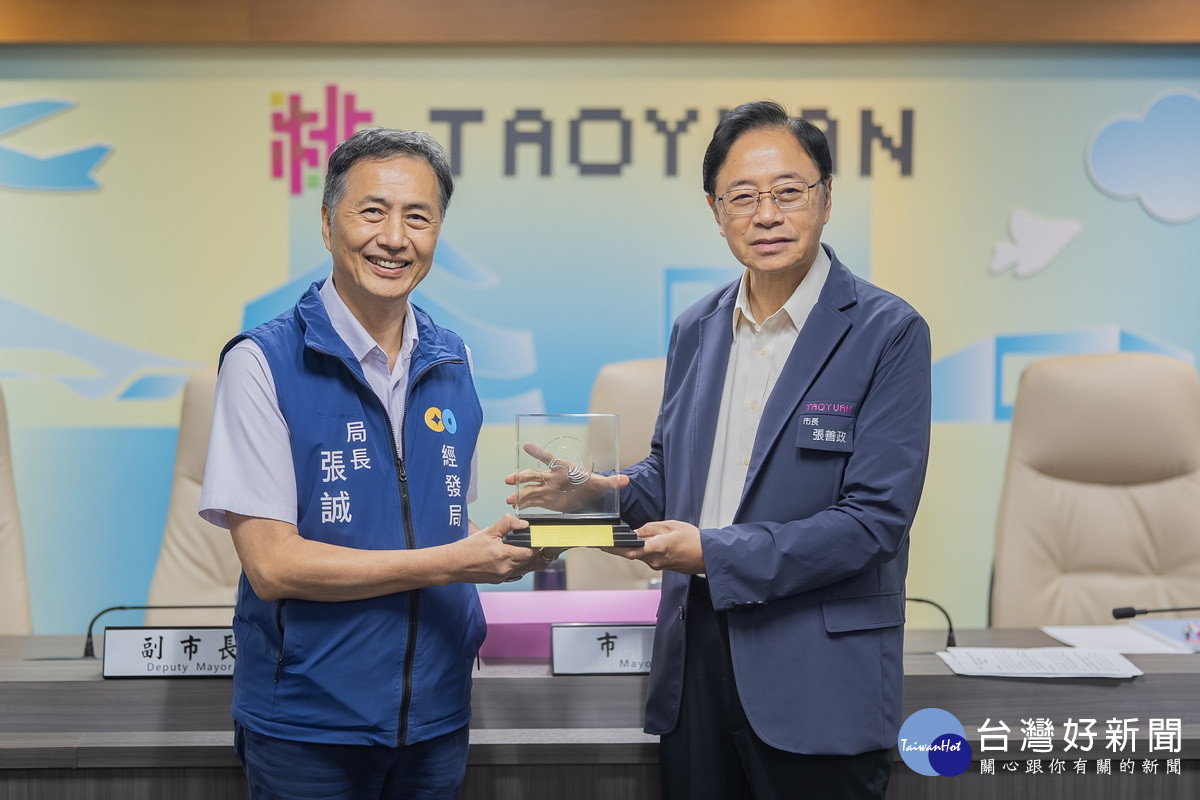桃園市長張善政接受經濟發展局長張誠獻獎。<br />
