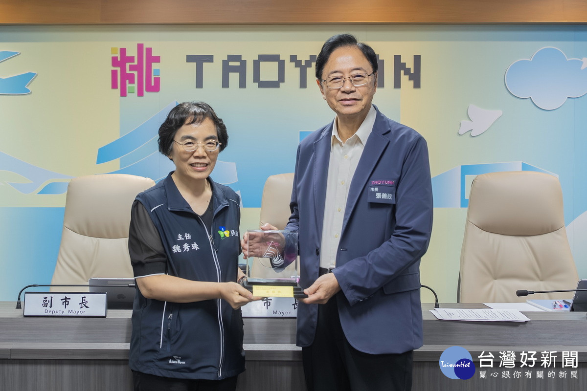 桃園市長張善政接受龜山區戶政事務所主任魏秀珠獻獎。