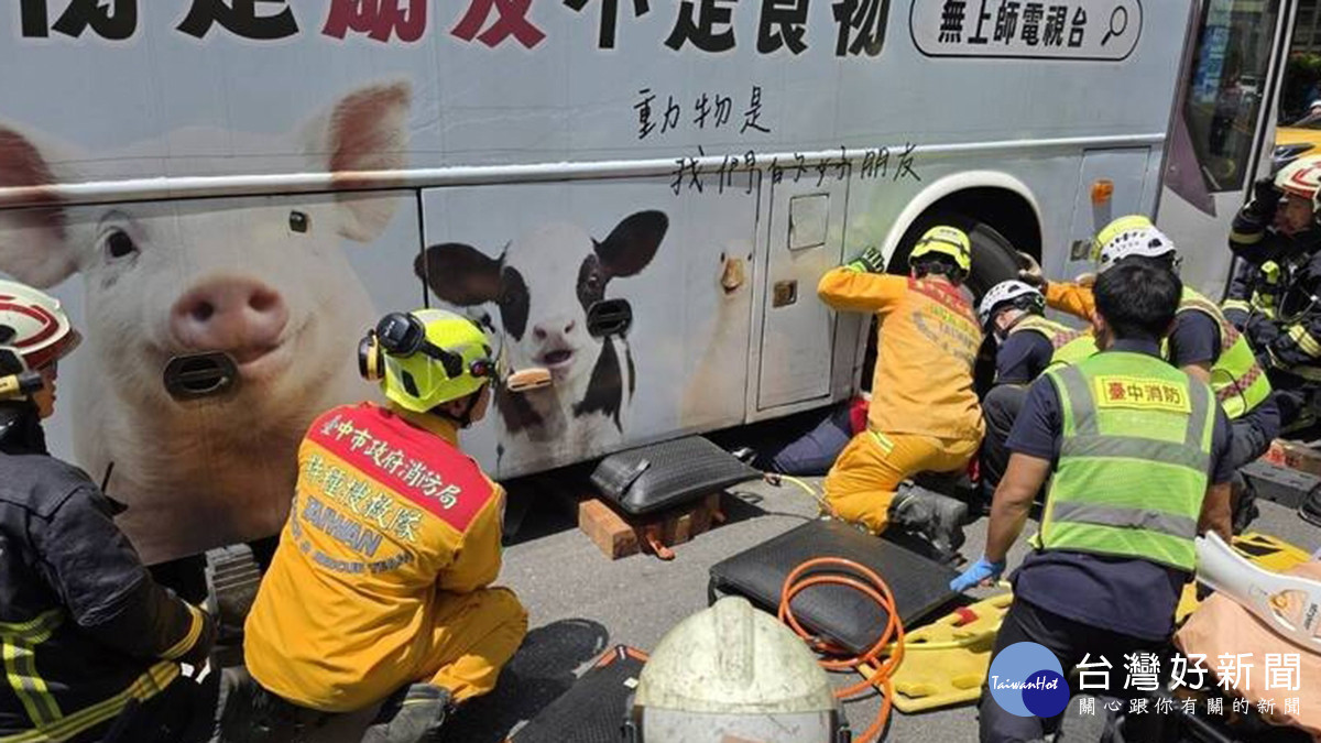 國光客運右轉撞上新加坡女遊客，女子受困車底，警消緊急救出送醫搶救。（圖/翻攝畫面）